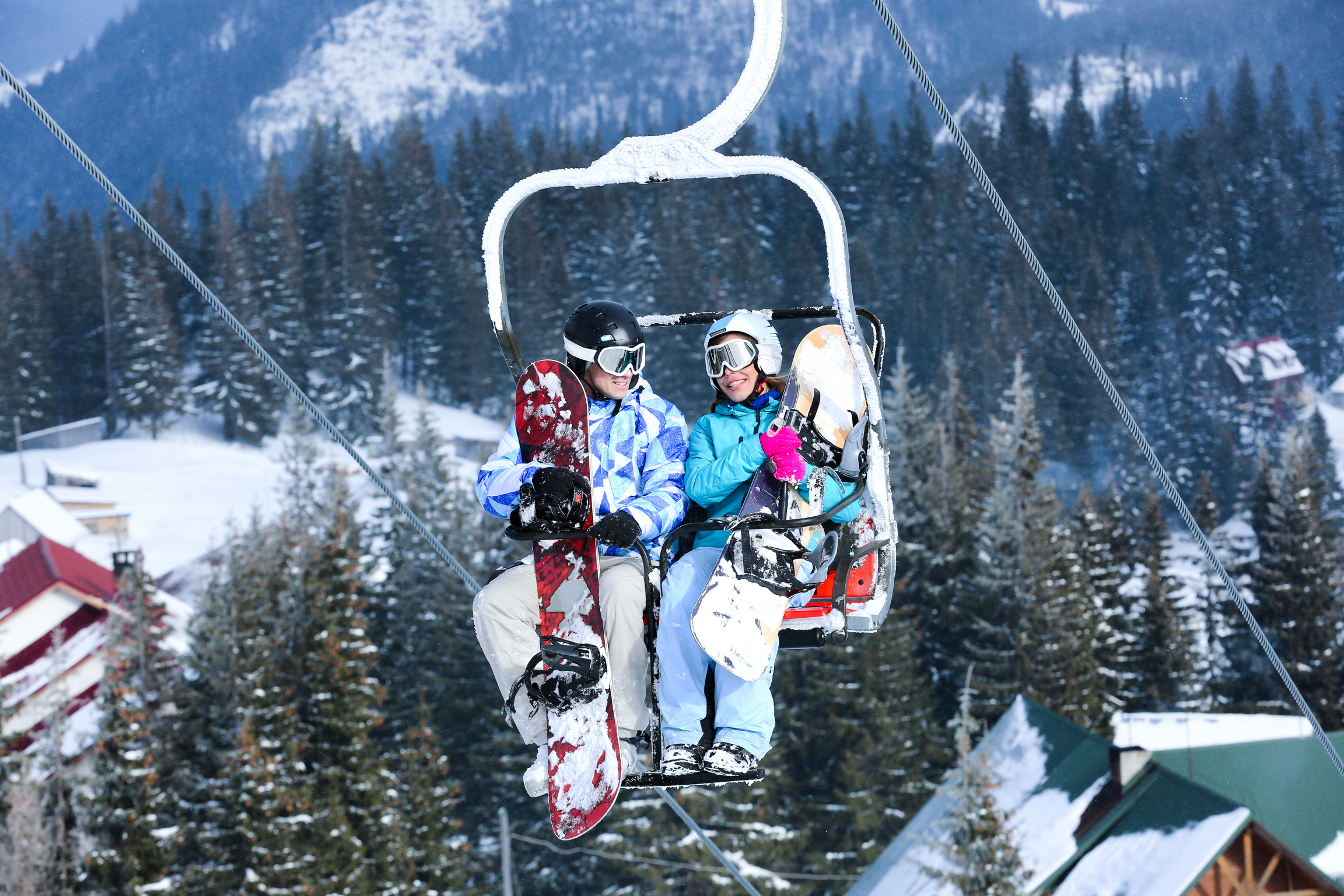 Young Couple Riding Ski Lift at a Ski Resort 